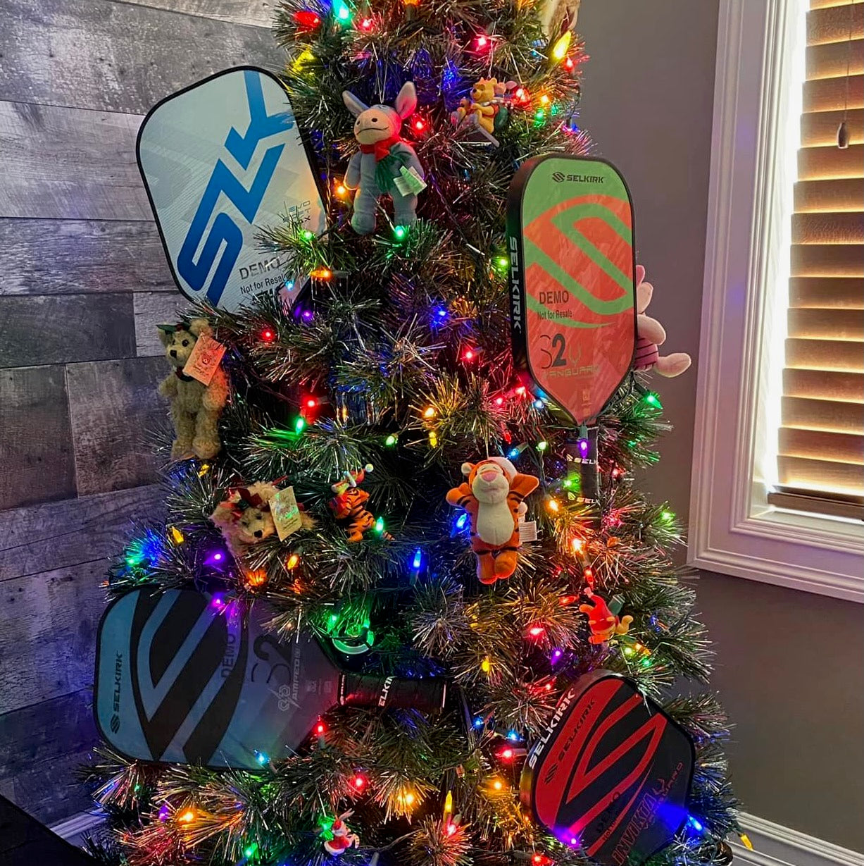 A christmas tree has four Selkirk Paddles resting throughout its branches. 