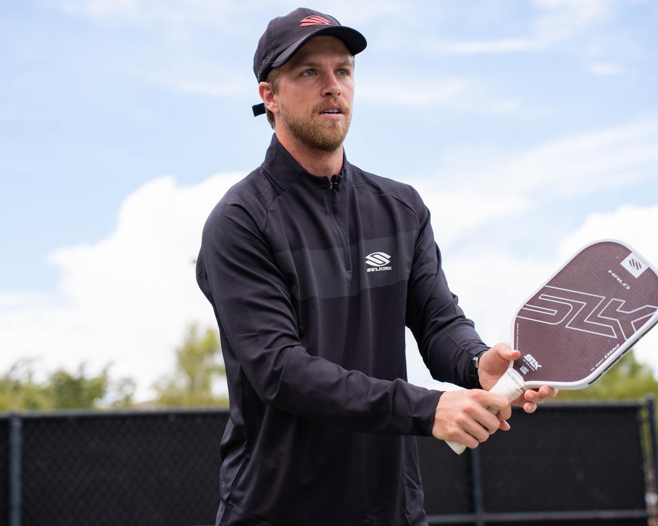 A man prepares for a volley shot with his SLK Halo Pro pickleball paddle. 