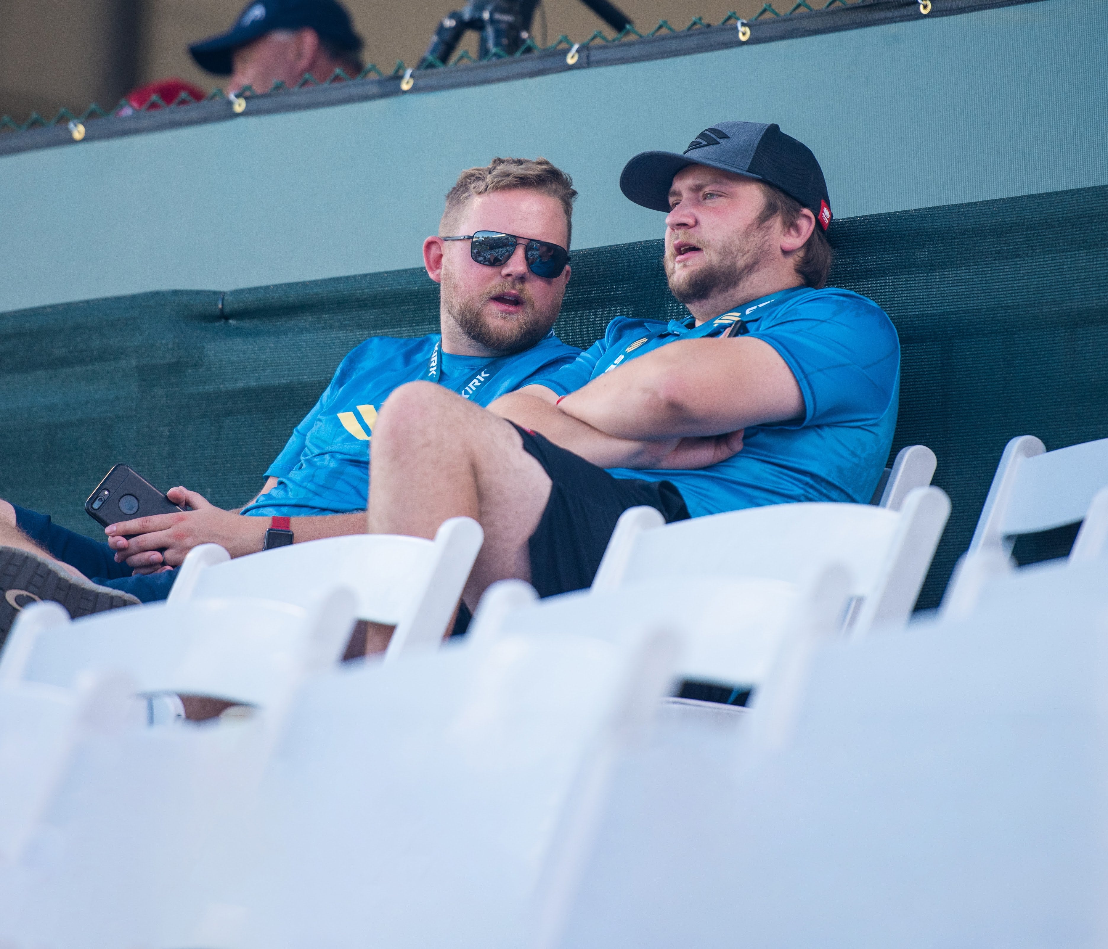 Rob and Mike Barnes, the co-founders of Selkirk, sit in the stands and talk at a professional pickleball event. 