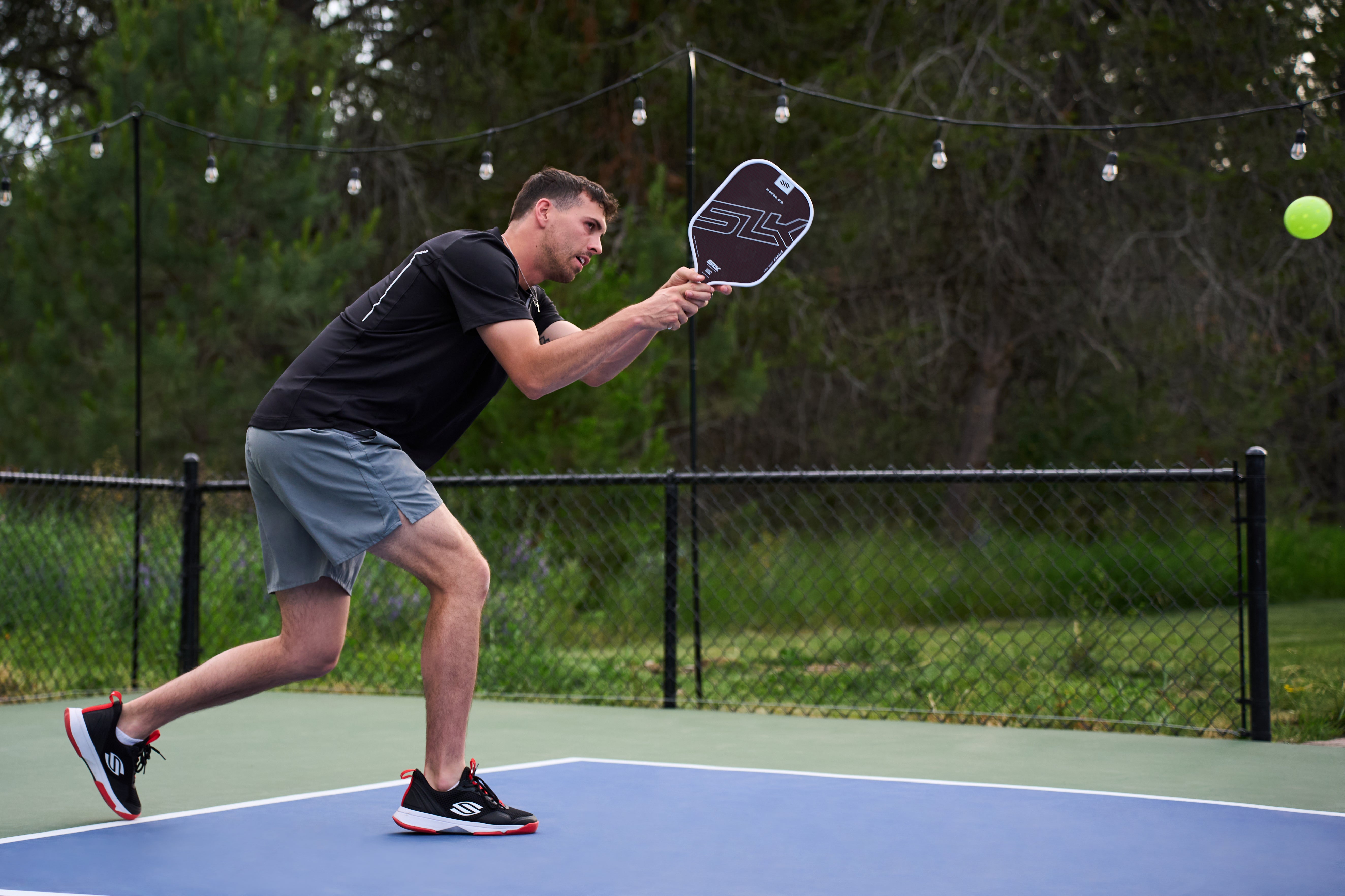 How long should pickleball shoes last? Photo of SLK pickleball paddle with Selkirk pickleball shoes.