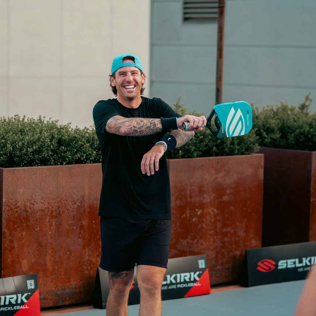 Hockey player James Neal smiles as he swings his Selkirk Luxx Control Air pickleball paddle. 