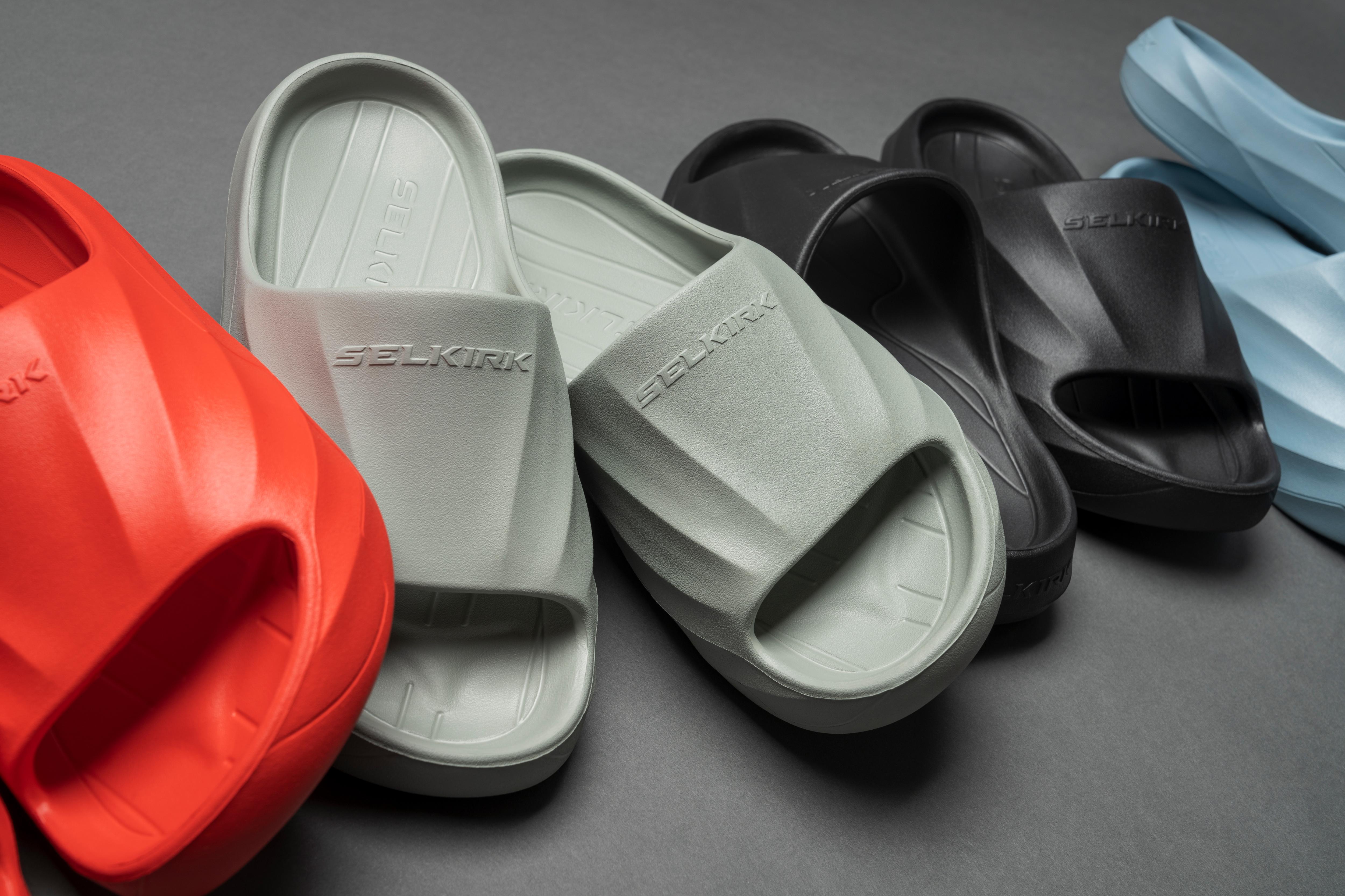 Selkirk pickleball slides shoes in black, grey, red, and blue.